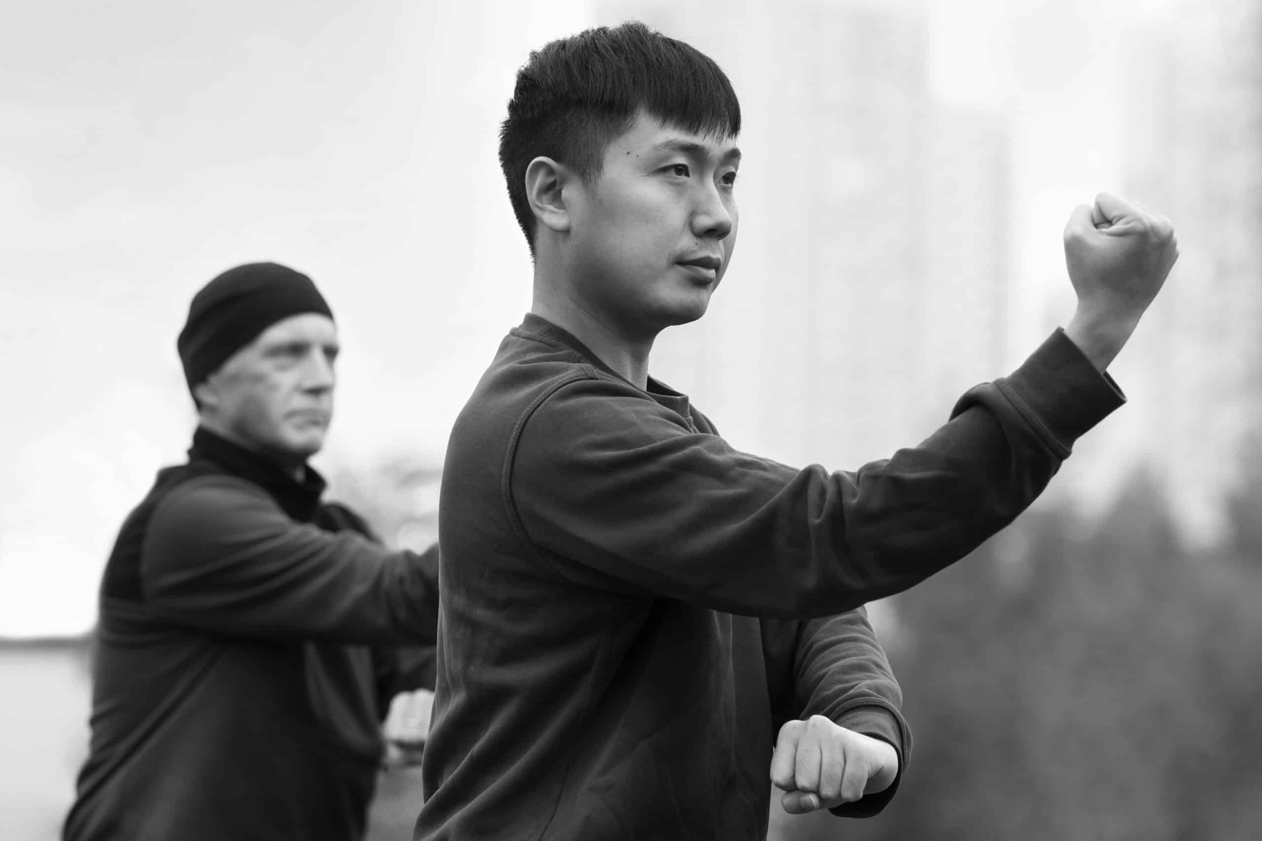 side view people practicing tai chi outdoors scaled